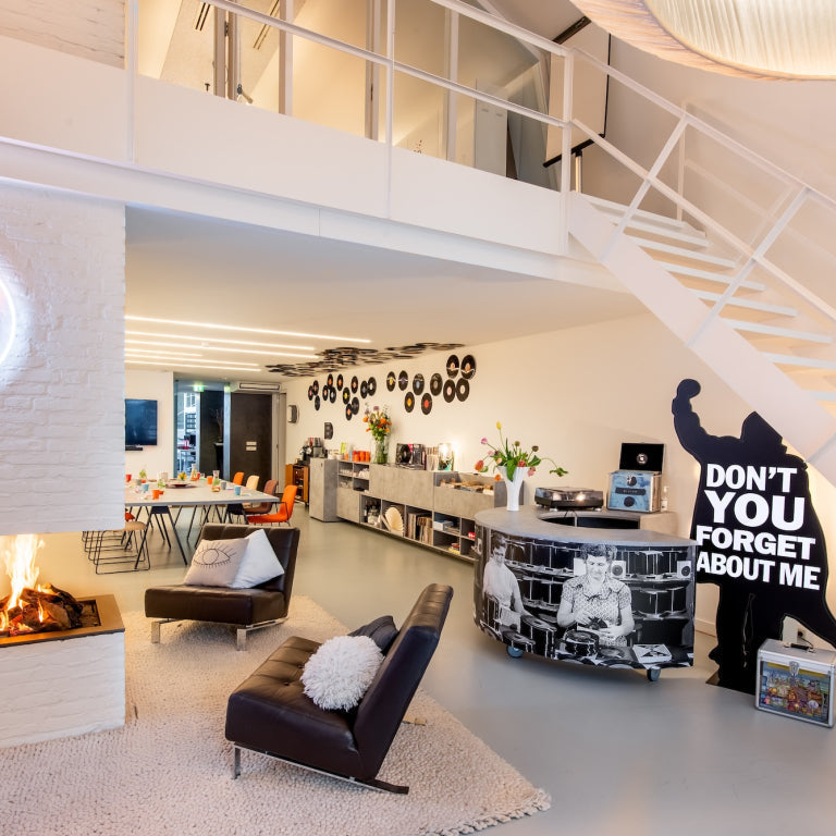 Interieur van de Music Meeting Lounge in Amstelveen met vergadertafel, luisterhoek, platenspeler en vinylplaten aan de wand.