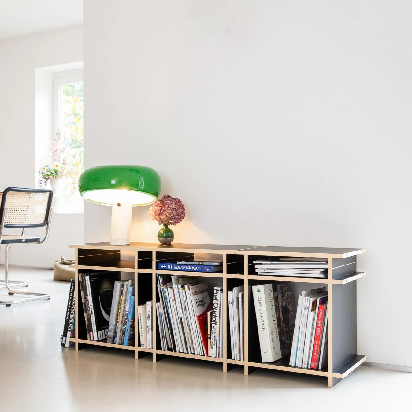 Kiyo R1 platenkast met platenspeler, luidspreker, vinylplaten en open opbergvakken in een modern interieur