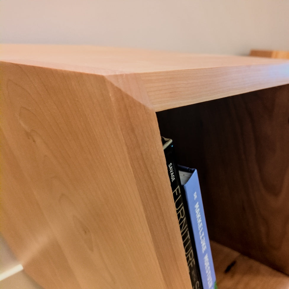Detail van de schuine platenvakken en warme houtnerf van de Studio Bours Curtis vinylkast
