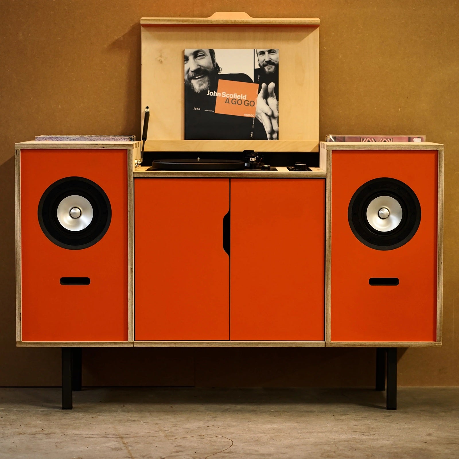 Plyphonic Model B audiomeubel met geïntegreerde platenspeler, luidsprekers en oranje deuren voor vinylopslag