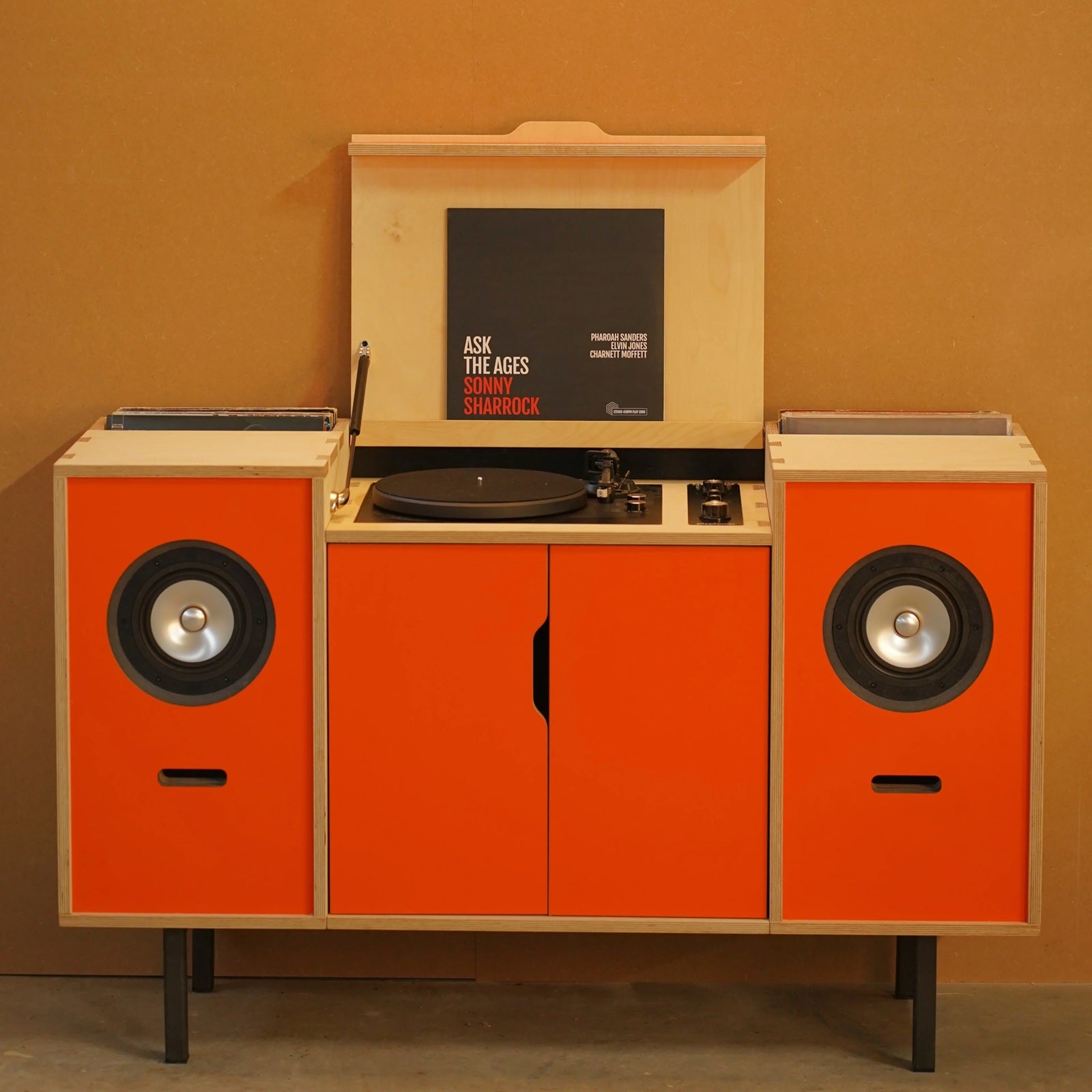Vooraanzicht van het Plyphonic Model B hifi-meubel met platenspeler, twee speakers en bakken voor vinylplaten