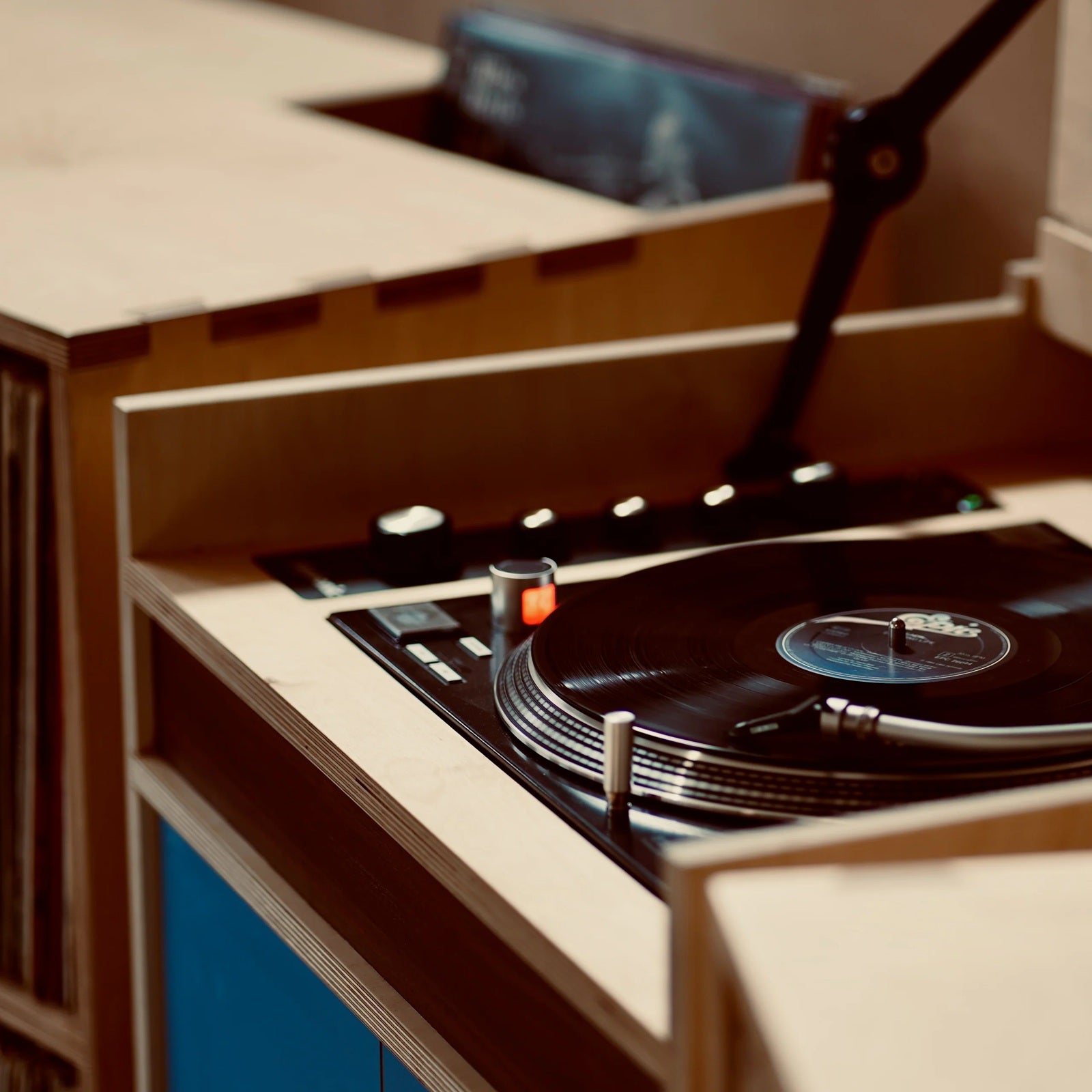 Draaiende vinylplaat op de geïntegreerde platenspeler van het handgemaakte Plyphonic Model A audiomeubel