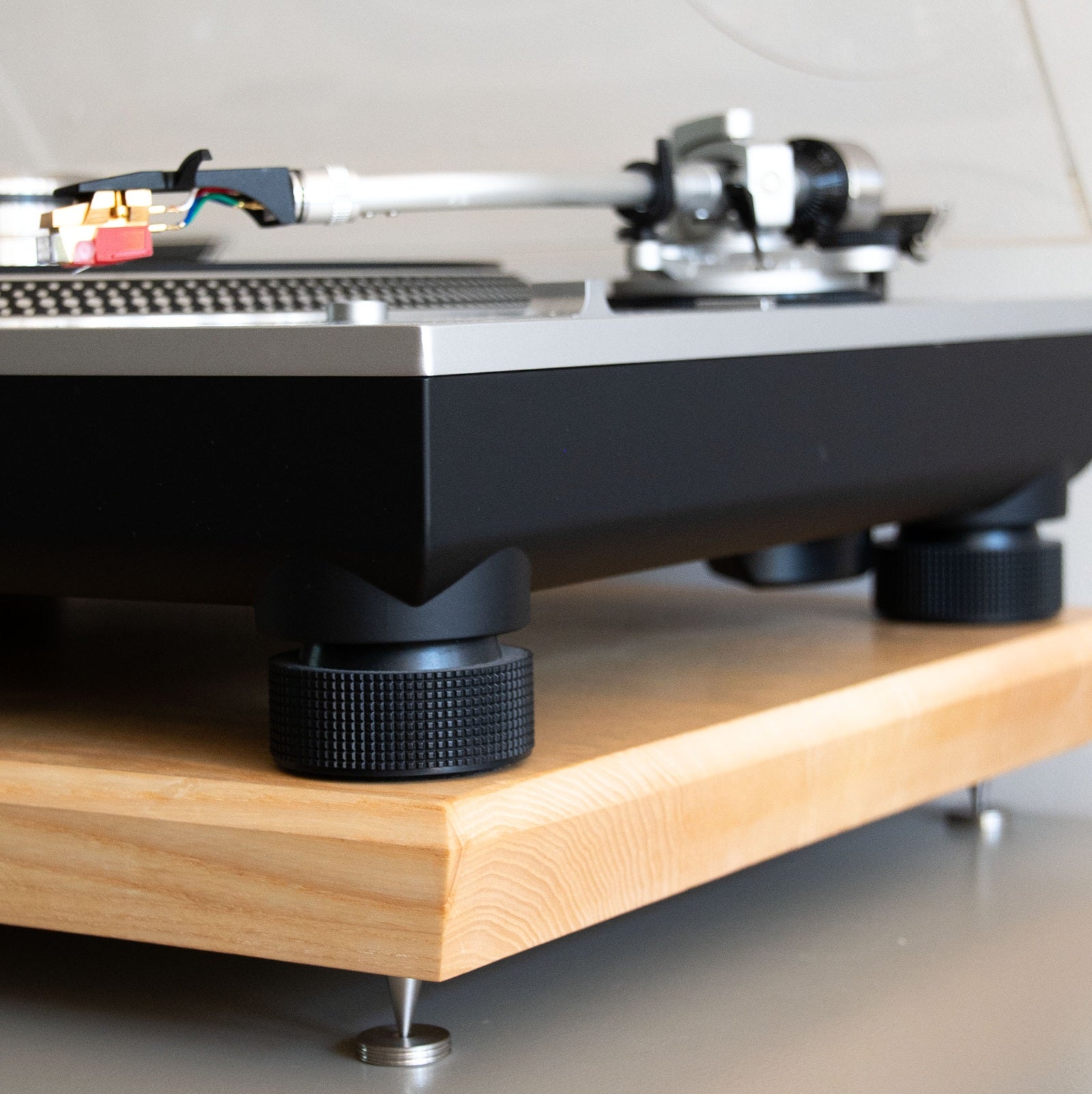 Detail van een platenspeler op de houten Dizzy resonantieplaat met metalen spikes voor trillingsdemping