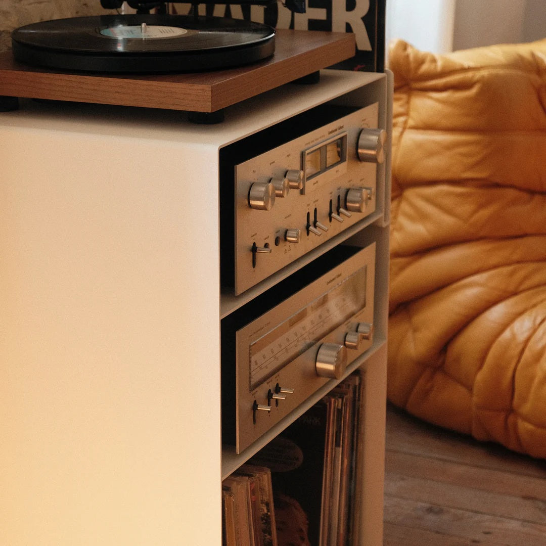 Detail van de witte stalen LOIA platenkast met houten platenspeler en vintage versterker en tuner