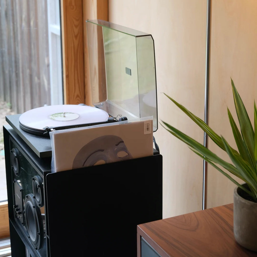 Zijaanzicht van de LOIA platenkast met draaiende platenspeler en houder voor de afgespeelde platenhoes