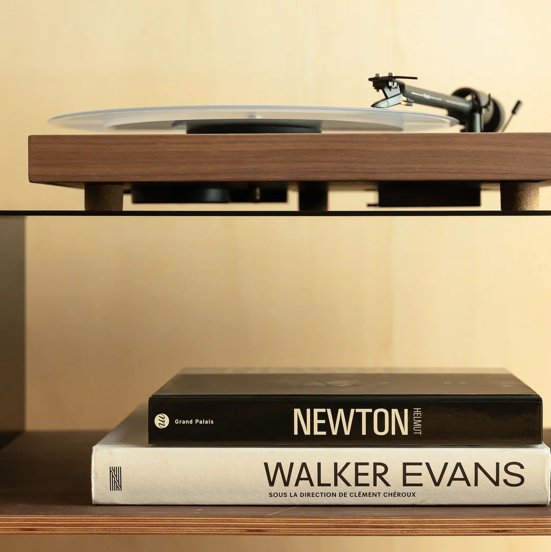 Detail van een platenspeler op het zwarte LOIA hifi-meubel met walnoten legplank voor audioapparatuur