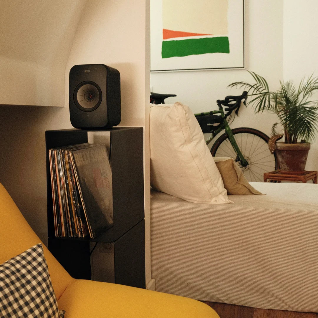 LOIA Le Pied platenkast met speaker en vinylcollectie naast een bank in een modern interieur