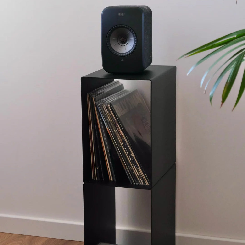 Schuin vooraanzicht van de LOIA Le Pied platenkast met speaker en vinylplaten in het bovenste vak