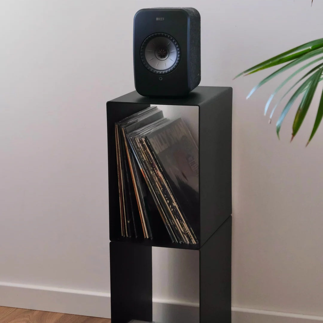 Schuin vooraanzicht van de LOIA Le Pied platenkast met speaker en vinylplaten in het bovenste vak