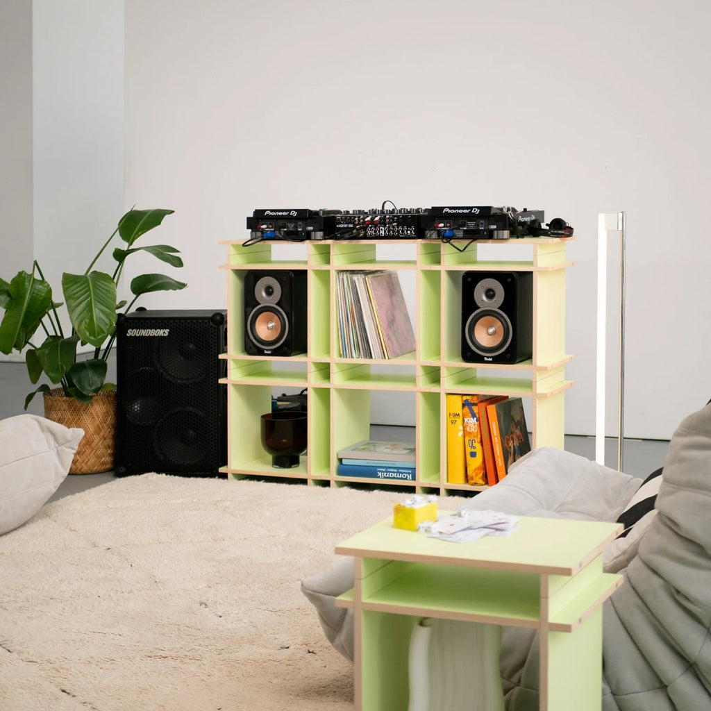 Limegroene Kiyo platenkast met DJ-apparatuur, luidsprekers, LP-opslag en open vakken in een muziekkamer